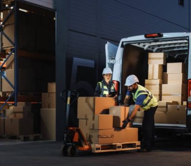 Outside of Logistics Retail Warehouse With Inventory Manager Using Tablet Computer, talking to Worker Loading Delivery Truck with Cardboard Boxes, Online Orders, Food and Medicine Supply, E-Commerce